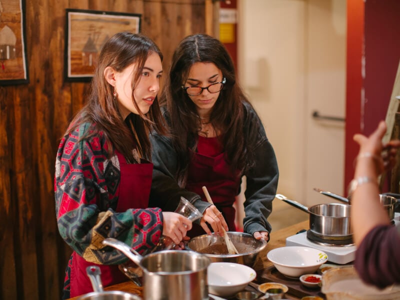 Women listening to a teacher at a cooking class